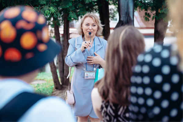 female guide is telling a group of tourists about something.