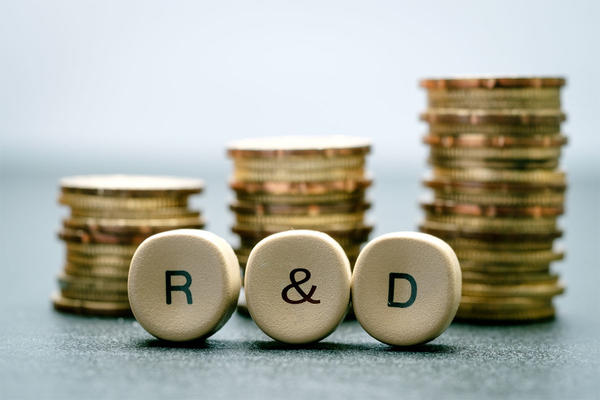 R&D letter block and stack coins, business concept. R&D stands for Research & Development.