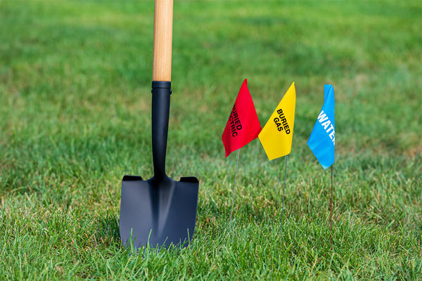 Buried electric, natural gas and water utility warning flag with shovel.