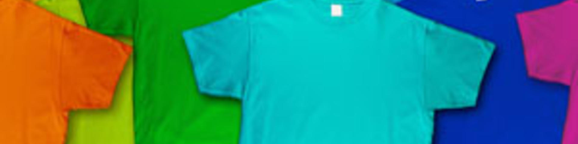 wide panorama banner row of many fresh new fabric cotton t-shirts in colorful rainbow colors isolated